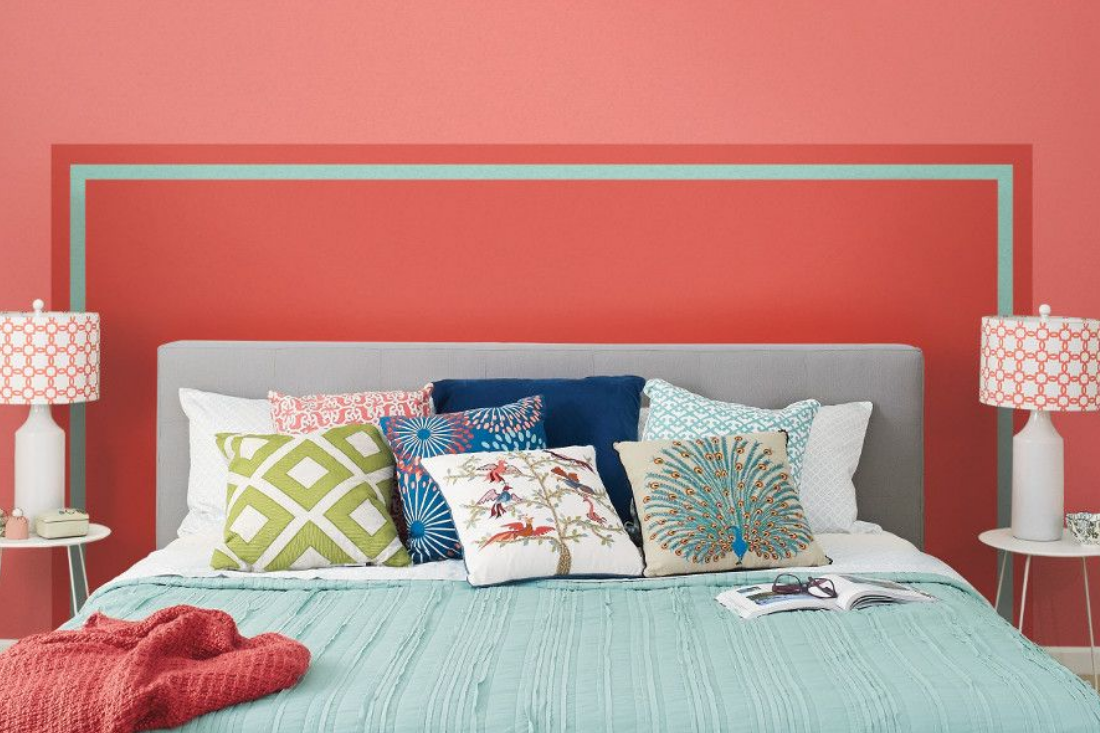 Bedroom, king bed with a paint-on headboard in the color luscious scarlet, trimmed in the color teal seagrass. Rest of wall painted carmela coral.