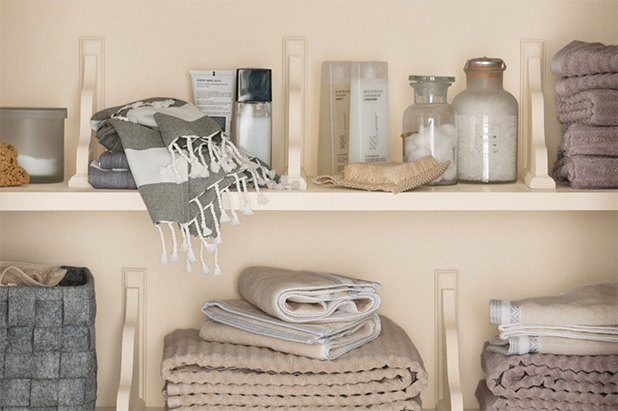Built-in wood shelving in a linen closet, painted in the color dust flats. 