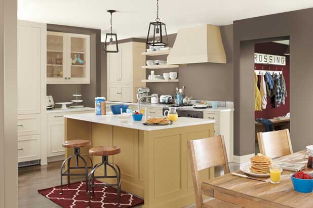 Breakfast is served in a large kitchen with island and dining table. Wall and backsplash are painted the same brown color.