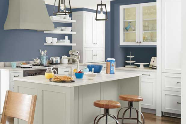 Bright kitchen with blue walls and backsplash contrast with white and light painted cabinets.