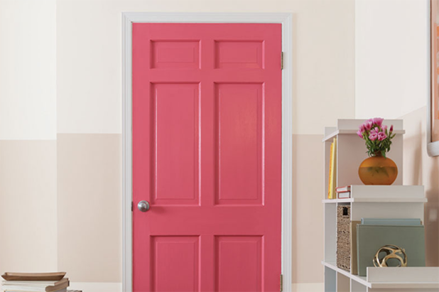 A door painted bright red, with a wall that features a dark beige horizontal stripe.