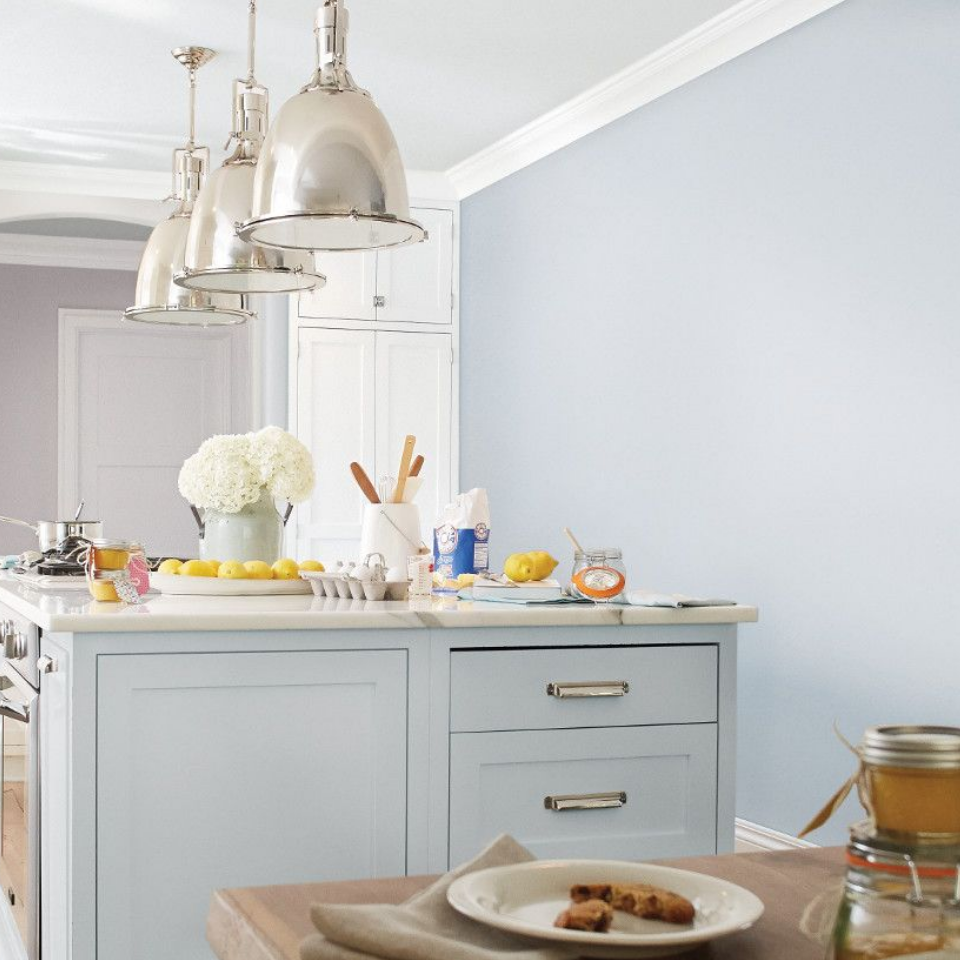 Large, modern kitchen island. Cabinets and wall are painted in the color Lil’ Snowflake.