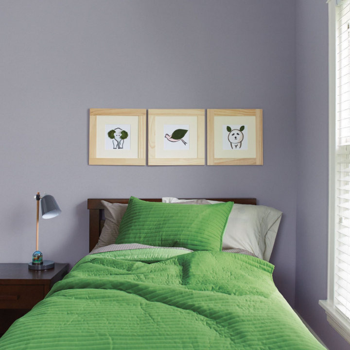 Minimalist children’s bedroom with line drawing art of animals framed on the color over-the-moon painted wall.