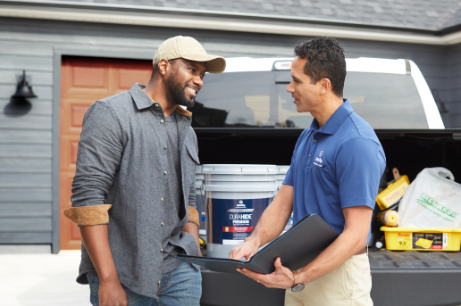 Contractor and Dutch Boy Professional Series Field Rep talking together in front of truck full of painting supplies, next to a residential home.